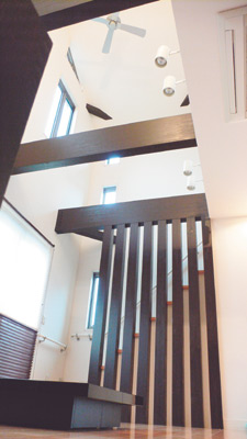 ご主人こだわりの吹き抜けになっていて、開放感のあるリビング。家具はすべて濃いめの色で統一され落ち着いた雰囲気になっている