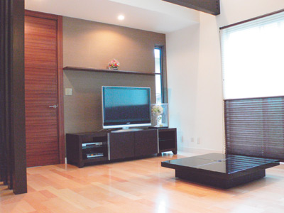 ご主人こだわりの吹き抜けになっていて、開放感のあるリビング。家具はすべて濃いめの色で統一され落ち着いた雰囲気になっている