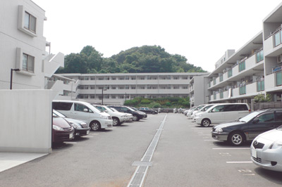 藤田さんのご新居は、駐車場を囲むように建つ白いタイル貼りの外壁がスッキリと明るい印象のマンション