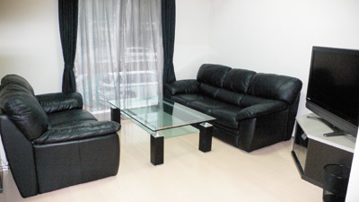 黒い家具が白い壁に良く栄え、モダンでシャープな印象のリビング