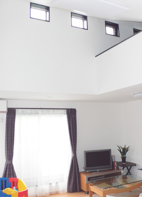 リビングは吹き抜け。高い勾配天井と明かり取りの窓が明るさと開放感を演出している