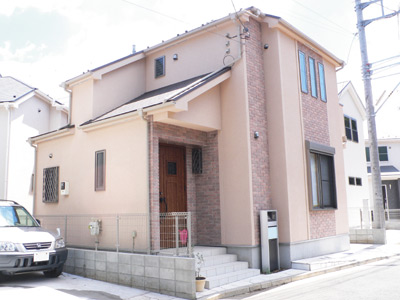 淡いピンクベージュの壁にレンガのアクセントがマッチした暖かみのある外観が目を引く金丸さんのご新居