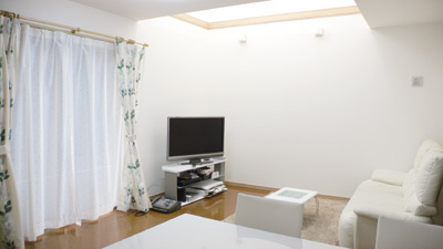 吹き抜けから明るい光が差し込む広々としたリビング