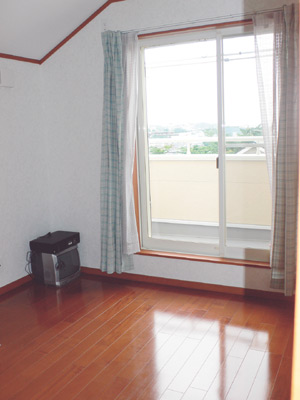 ベランダにつながる大きな窓のある6畳の洋室