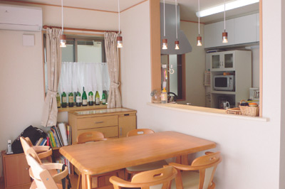 吊り戸棚のない開放的なカウンターキッチンとダイ二ング。オシャレな照明が食卓のアクセントに