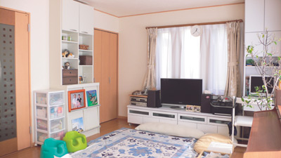 南と東に窓があり、明るいリビング。白い家具やラグが明るさを引き立てている