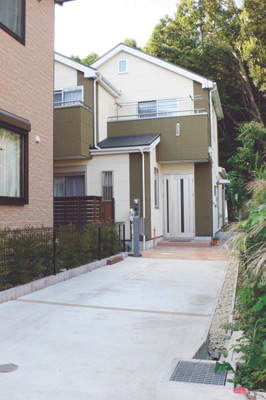 緑豊かな環境に建つ、外壁の2色のカラーが個性的な小嶋さんのマイホーム。手前は2台分のカースペース