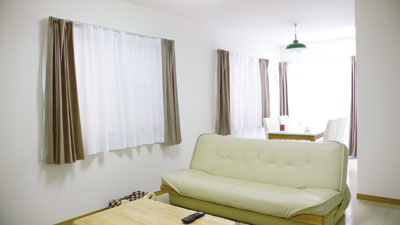 大きな窓の横はソファー同様白いダイニングセットが置かれた明るいダイニングスペース