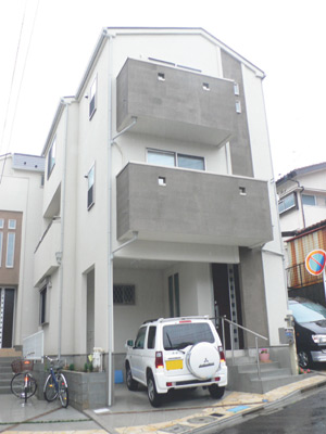 小松家の外観は壁の白とバルコニーのグレーがモダンな印象。左右の家との間隔も十分保たれている