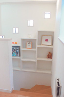 階段の壁に設けられているのは、写真などを自由に選んで飾ることができる作り付けの飾り棚