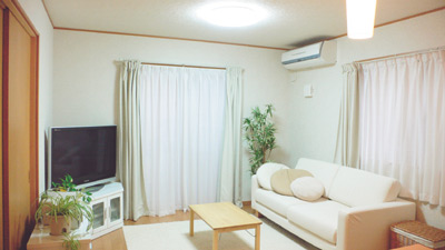 大きめのソファがゆったりと置かれたリビング。ソファやカーペットの色が部屋を明るく見せてくれる