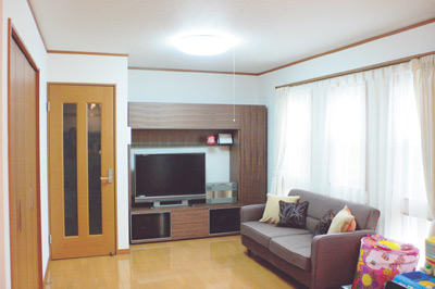 窓が大きく明るいリビングは、ブラウン系の家具が置かれ落ちついた印象