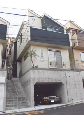 お庭に植えられた木が、建物の外壁のシックなモノトーンに個性的な色合いを添えている