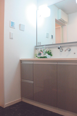 スッキリと清潔感のある洗面スペース。洗面台や床材の色に個性が感じられる