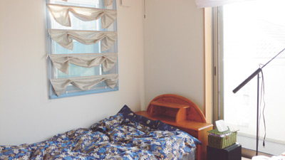 バルコニーにつづく大きな窓からたっぷりと光が入る明るい部屋が松石さんの寝室