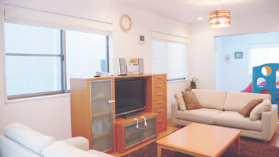 窓が多く、風通しの良いリビング。家具や照明が暖かい雰囲気を作り出している