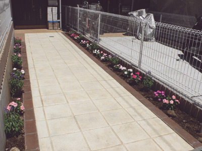 玄関までのアプローチは両脇がかわいい花で飾られている