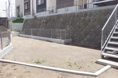 家の裏手から階段を下りた場所にはブロックとフェンスで囲まれた広いお庭が