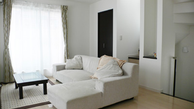 明るい色の床材と、大きなソファーの白が部屋を一層明るく見せているリビング