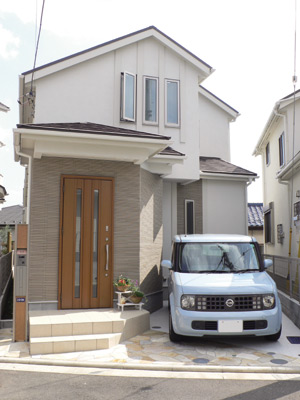手前にカースペース、建物奥に庭のある西海さんのお宅。白とベージュが優しい印象