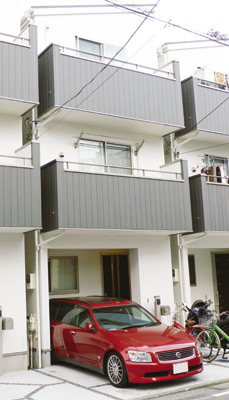 壁の白とバルコニー部分のグレーがモノトーン風のコントラストを作り出すモダンな外観