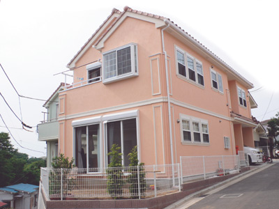 淡いオレンジの優しい色あいと窓の白い縁取りが南仏の家を思わせる小澤さんのお宅