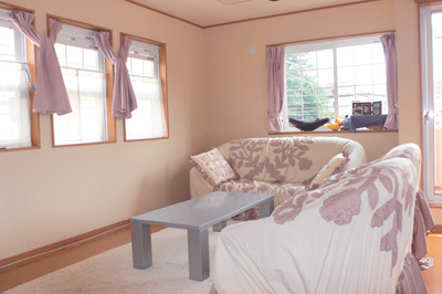 壁紙の色と生成りのソファーカバーがよく合った、暖かい印象のリビング