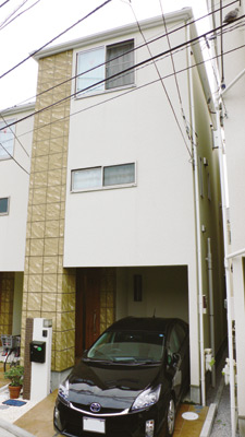 白い外壁の一方の角にベージュのタイルが張られたアシンメトリーな外壁が個性的な佐藤さんのお宅