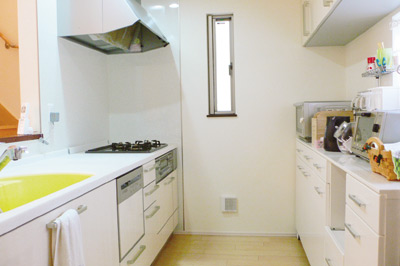 清潔感のある白いシステムキッチン。対面式で収納も多く、とても使い勝手が良いとのこと