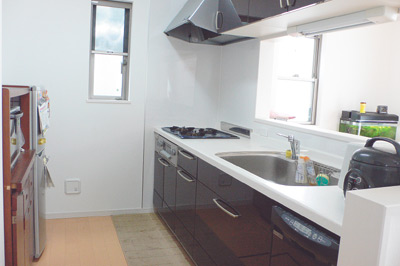 対面式の明るいキッチンは、白と黒のコントラストがシックな印象