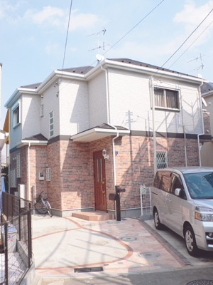 １階は暖かいレンガ色、２階はスッキリとした白という２色使いが個性的な柘植さんのお宅