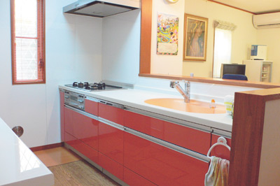 ご自分で選ばれたというシステムキッチンの色は明るいオレンジ。ブラインドやシンクもオレンジ色に統一されている