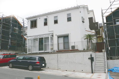 サンルームとフェニックス(椰子の木)が印象的な、渡辺さんのお宅。ジョリパットという素材で塗装した壁も奥さまのこだわり