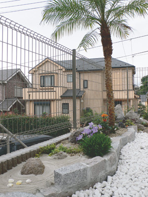 フェニックスを中心に、カラフルな花々がよく栄える南国風のお庭