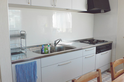 壁付けタイプのシステムキッチンは清潔感のある白。シンクが大きく、とても使いやすいとのこと