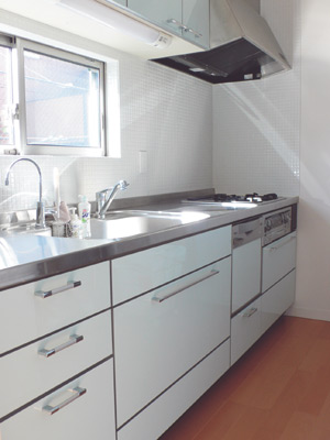 タイル貼りの壁がオシャレな白いキッチンは奥さまのご希望どおりの壁付けタイプ