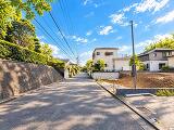 青空の下に広がる、穏やかで落ち着いた住宅街。周囲には戸建住宅が並び、緑も感じられる街並みです。現地ならではの空気感もぜひご確認ください。