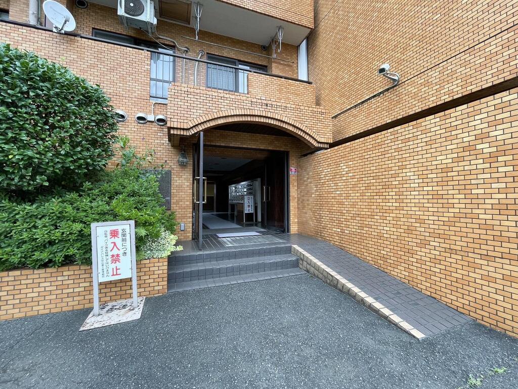 レンガ調の外壁が印象的なマンションエントランス。スロープも設けられており、日々の出入りにも配慮されています。